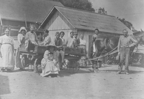 Dierker family at their ranch with wagon of apricot boxes, Orange, California, ca. 1910