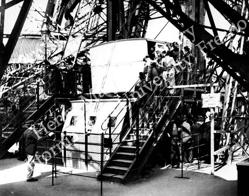 Fairgoers entering and exiting the Eiffel Tower elevator
