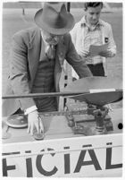 Sports official using a scale at a track meet between UCLA and USC, Los Angeles, 1937