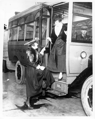 [Two women standing at the entrance to an early Muni bus]