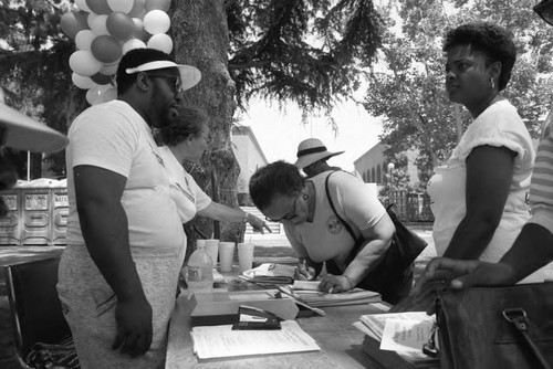 Participants visiting an exhibitor at the Black Family Reunion in Exposition Park, Los Angeles, 1989