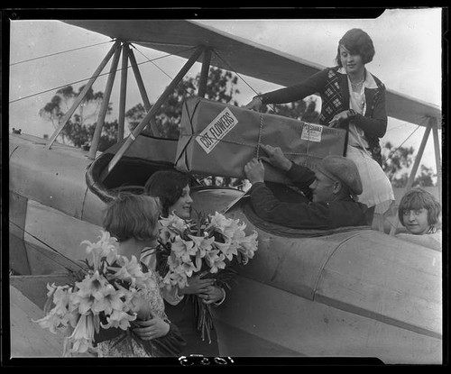 Young women and pilot with airplane and Easter lilies, Los Angeles, 1931