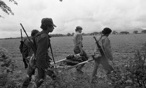 Sandinistas carry a dead man on a stretcher, Nicaragua, 1979