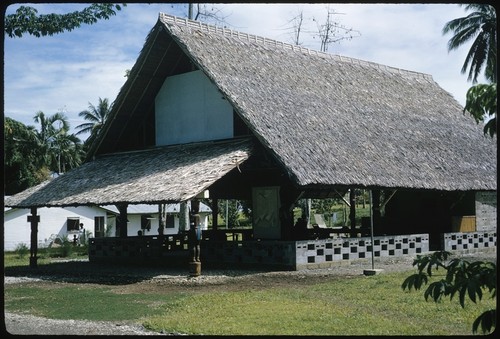 Large building with thatched roof, sculptures, Makira