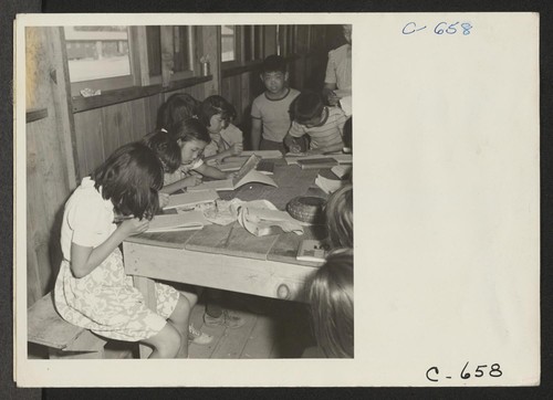 Manzanar, Calif.--These young evacuees are attending the first elementary school at this War Relocation Authority center. There are six grades with volunteer teachers and voluntary attendance. Photographer: Lange, Dorothea Manzanar, California