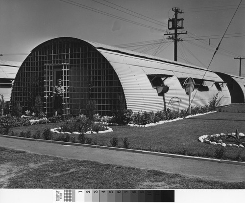 Photograph of woman at front door of Quonset hut in Rodger Young Village