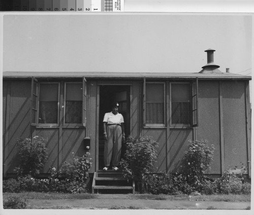 Photograph of African American woman standing in doorway of unit at Corregidor Park