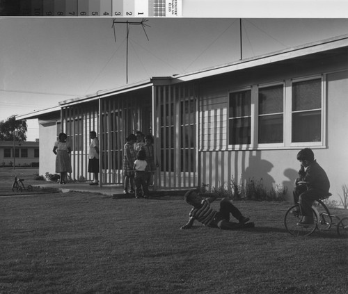 Photograph of children at play in front of a Hacienda Village housing unit