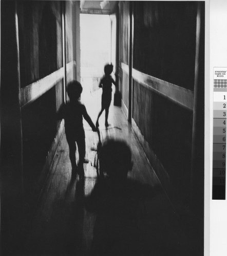 Photograph of three children in a dark hallway