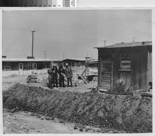 Photograph of four men surveying the site of Hacienda Village