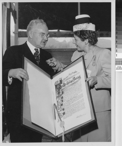 Photograph of Mayor Fletcher Bowron presenting award citation to Mrs. Rodger Young