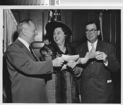 Barbara Rosien, Assistant Executive Director of the Housing Authority of the City of Los Angeles, presenting checks to Mayor Poulson and Governor Knight