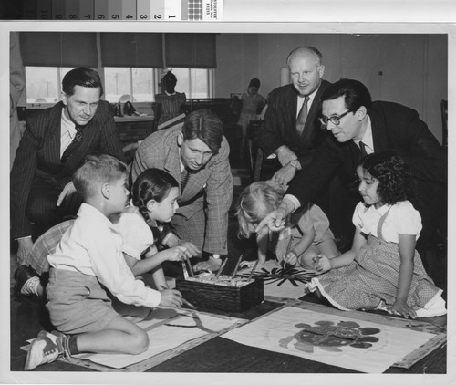 Photograph of several German educators visiting with children at a public housing project in Los Angeles