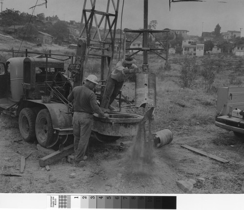 Photograph of two men boring earth at the proposed site of Elysian Park Heights