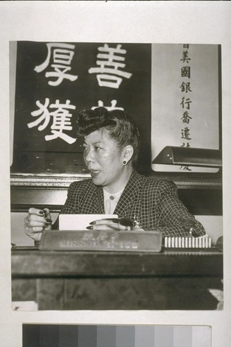 [Woman at desk.]