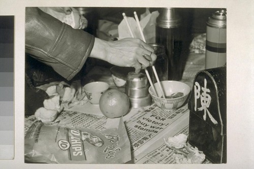 [Unidentified hand with chopsticks.]