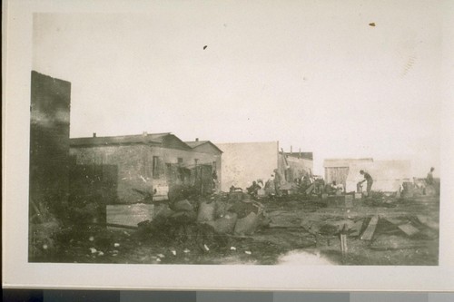 After the fire. The bank walls and the heard[sic] store in the background. This shows the commotion soon after the fire in the rear of the building