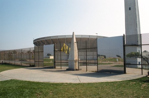 Picturing Paradise: Border fence from U.S. side with mirrored surfaces and bullfight stadium in the background