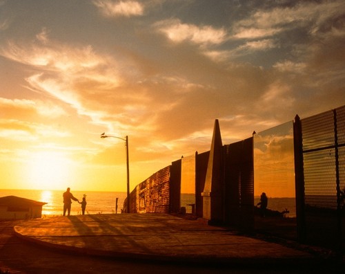 Picturing Paradise: Border fence with mirrored surfaces at sunset