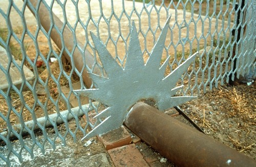 International Waters: detail of pipe penetrating the border fence