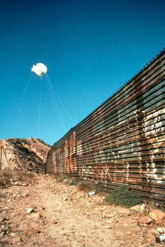 The Cloud: white balloons suspended in the sky over the United States/Mexico border wall