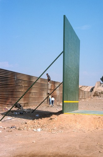 The Rules of the Game: ball court and border fence with children playing