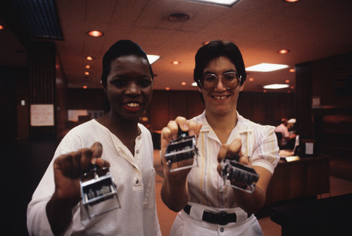 Paula Kapteyn and another library worker holding stamps