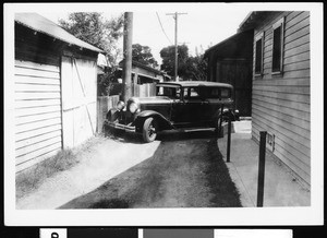 Automobile parked in an alley between homes, ca.1925