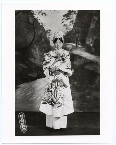Portrait of a standing actress in classical costume with wide sleeves and embroidered with landscape design /