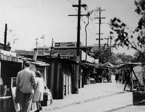 Shoppers in front of booths along Olvera Street