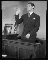 Henry Guttman, accused of theft, raises his right hand as he stands at the witness stand, Los Angeles, 1935