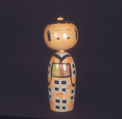 Blue and green kokeshi doll