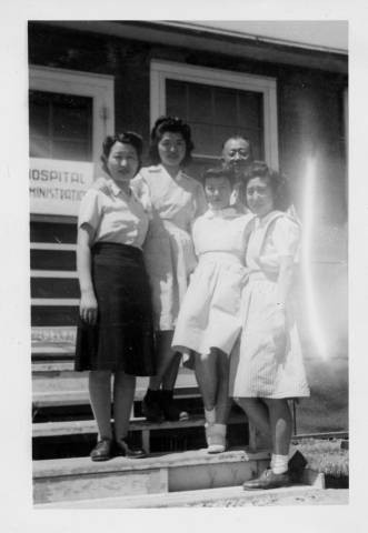 Dr. and Mrs. Akamatsu with nurses' aides on steps of hospital administration barrack at Tule Lake Relocation Center