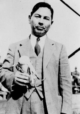 Reverend Jokai Kow holding 1934 Rural League champion baseball trophy