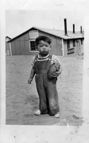 George Asato Nakano, Jr. holding football at Granada Relocation Center