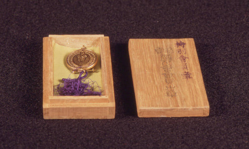 Medal with purple tassel in wooden box