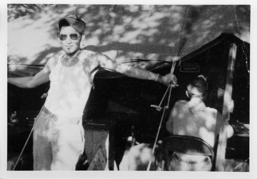 Paul Takehara standing outside tent at Camp Claiborne, Louisiana