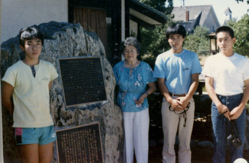 Mary Tsukamoto and three Japanese boys next to the Florin Buddhist Church plaque