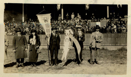 Men holding championship flag and medal at Ewing Field, San Francisco