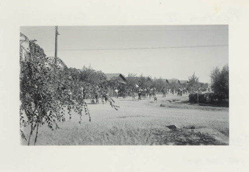 Line of students from Poston II Relocation Center school moving furniture