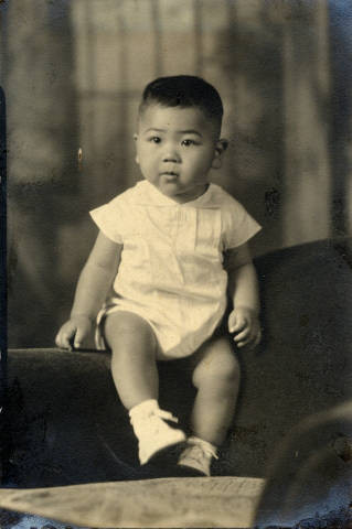 Kenji B. Matsuda seated on arm of chair