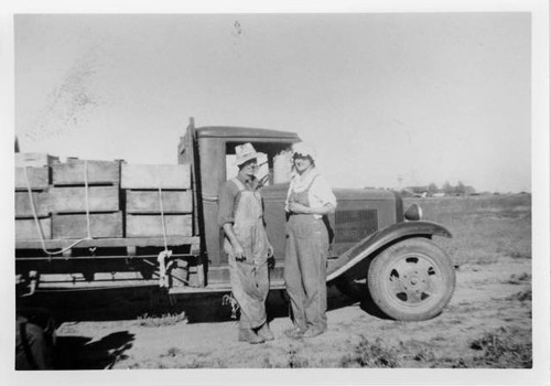 Man and woman standing alongside truck