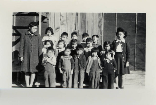 Young students at Poston II Relocation Center in front of barrack classroom