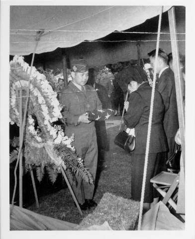 Tane Akiyama, mother of Zentaro (George) Akiyama, presented flag from son's casket by Henry Nakashima