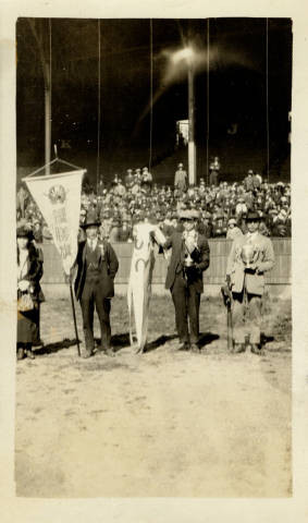 Men holding championship flags at Ewing Field in San Francisco