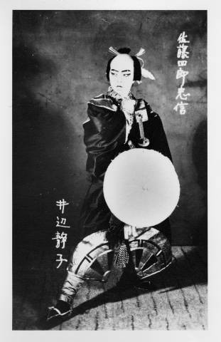 Shizuko Inbe as a male character holding a drum in a Kabuki play