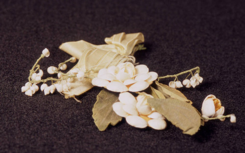 White shell corsage pin with green ribbon