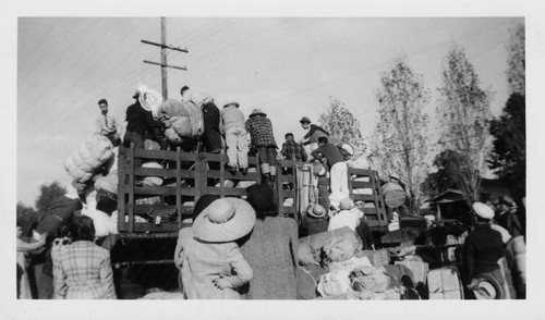 Japanese Americans pile luggage onto truck for evacuation