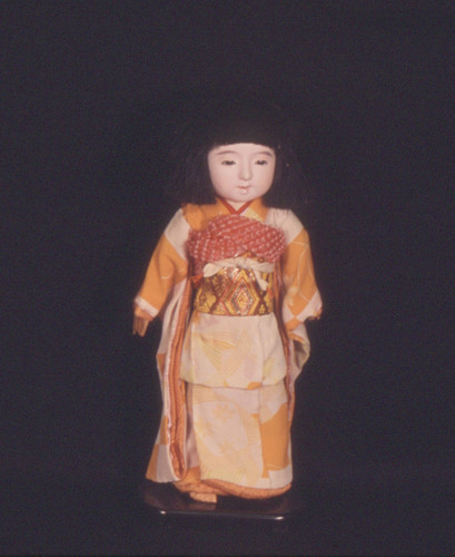 Japanese doll in orange print kimono