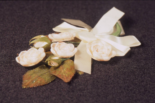Pink shell corsage pin with white ribbon